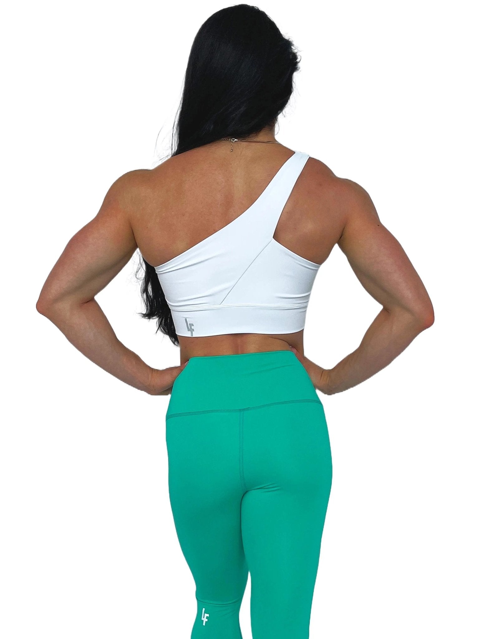 Mujer luciendo el top asimétrico Top Carmela de LUXFEEL en color Blanco, con diseño de un solo hombro y apertura en el escote