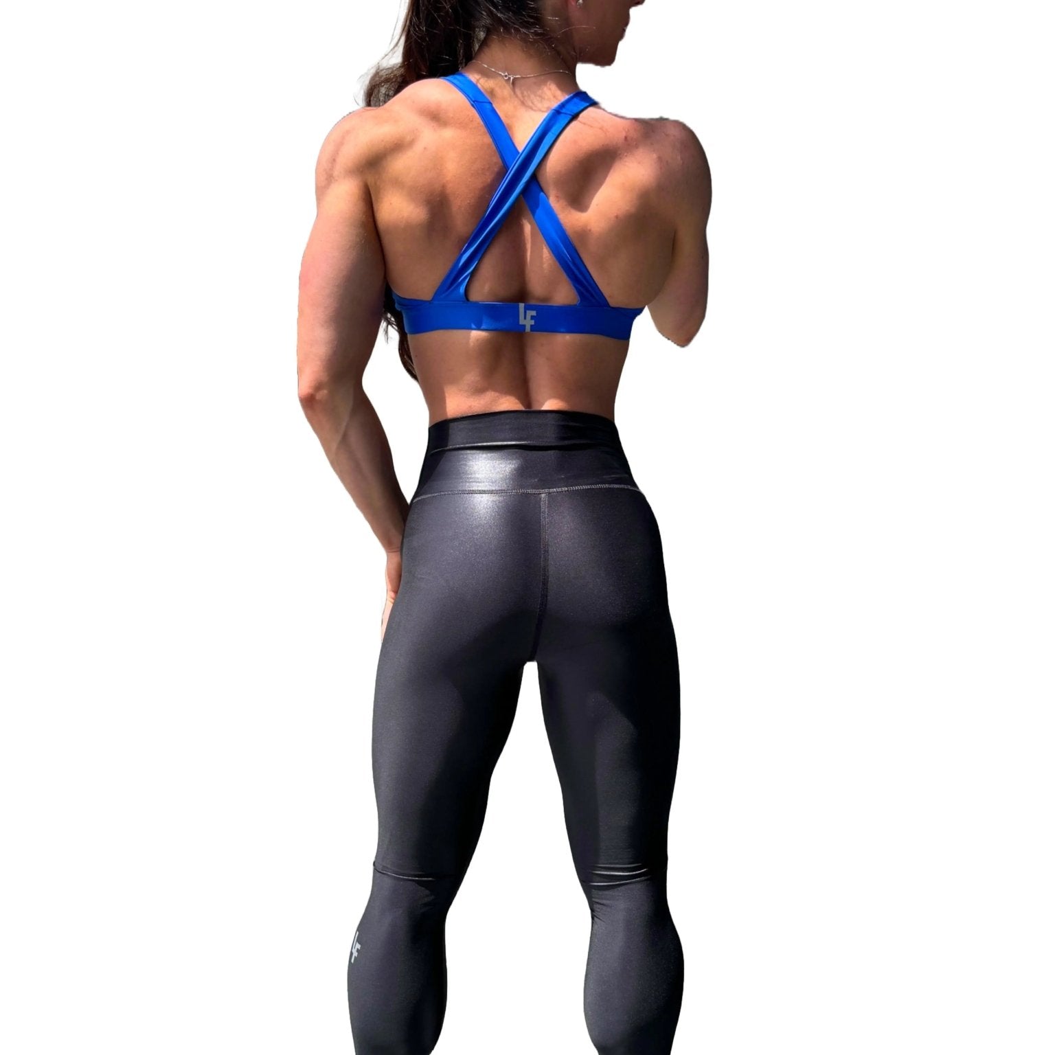 Mujer vistiendo el top deportivo Top Paula de LUXFEEL en color Azul, con sus tirantes convertibles en posición recta para un look clásico.