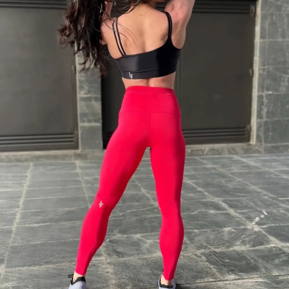 Mujer vistiendo el top deportivo Top Valentina de LUXFEEL en color Negro, con un romántico escote en forma de corazón.