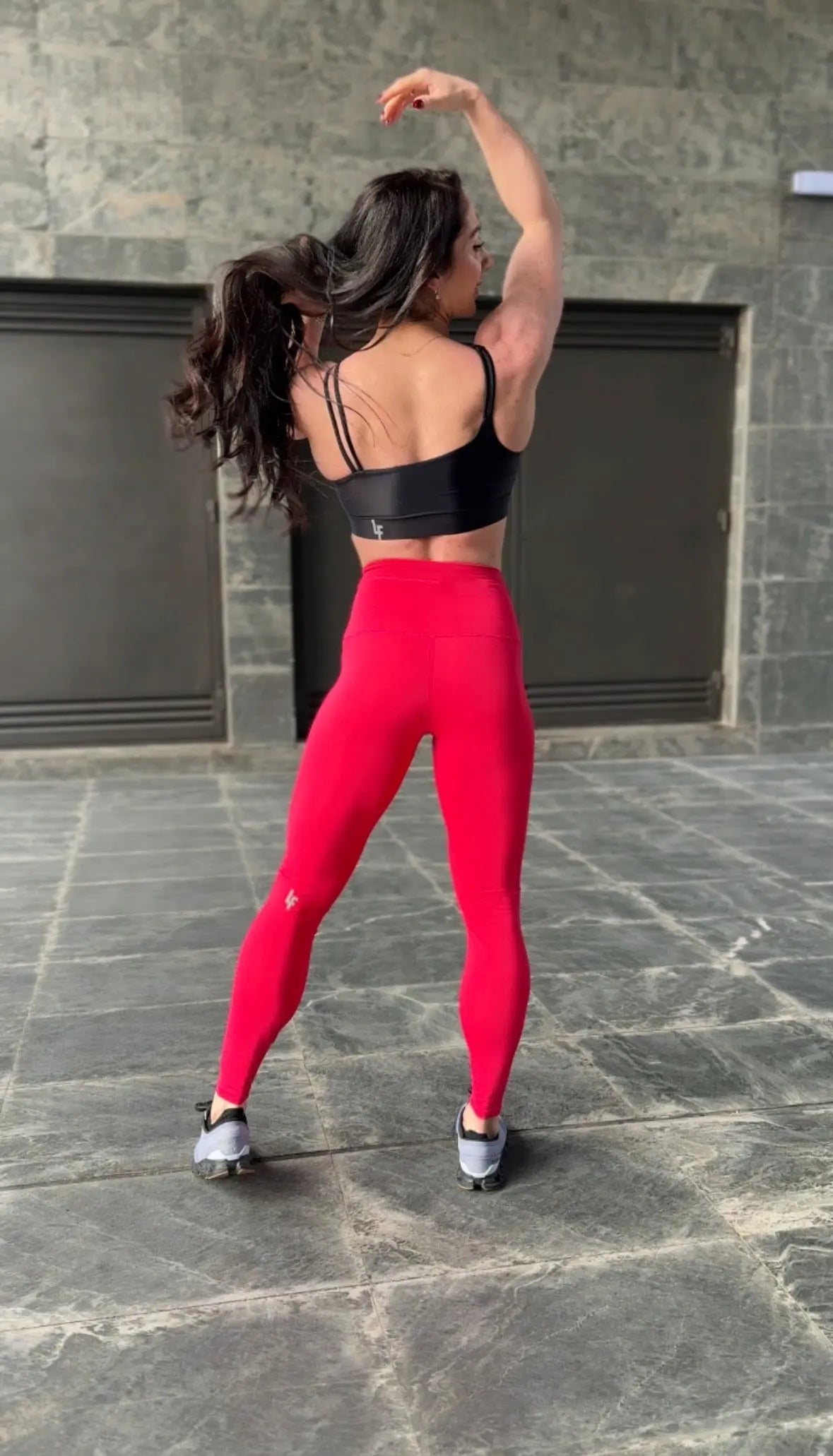 Mujer vistiendo el top deportivo Top Valentina de LUXFEEL en color Negro, con un romántico escote en forma de corazón.