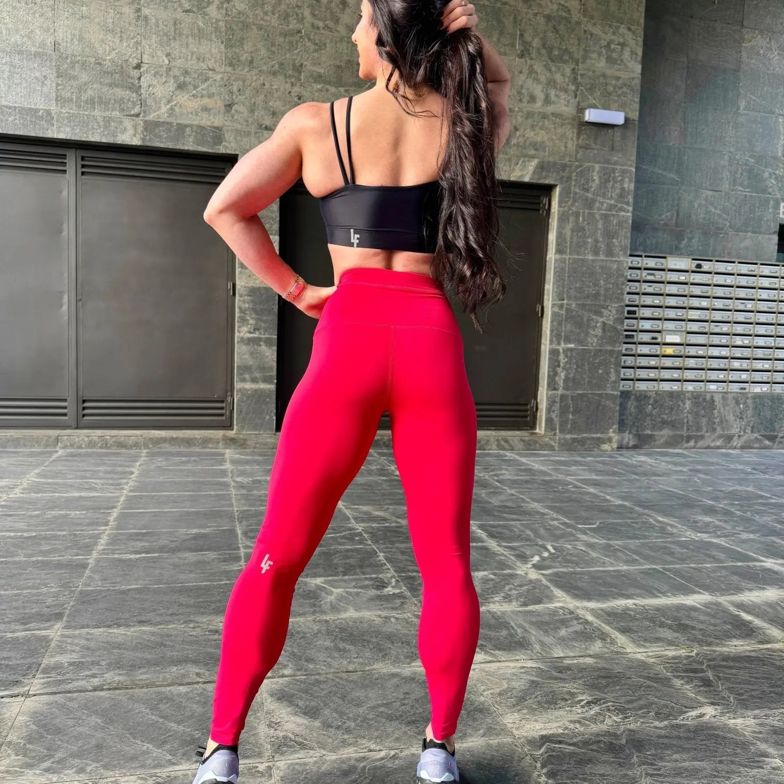 Mujer vistiendo el top deportivo Top Valentina de LUXFEEL en color Negro, con un romántico escote en forma de corazón.