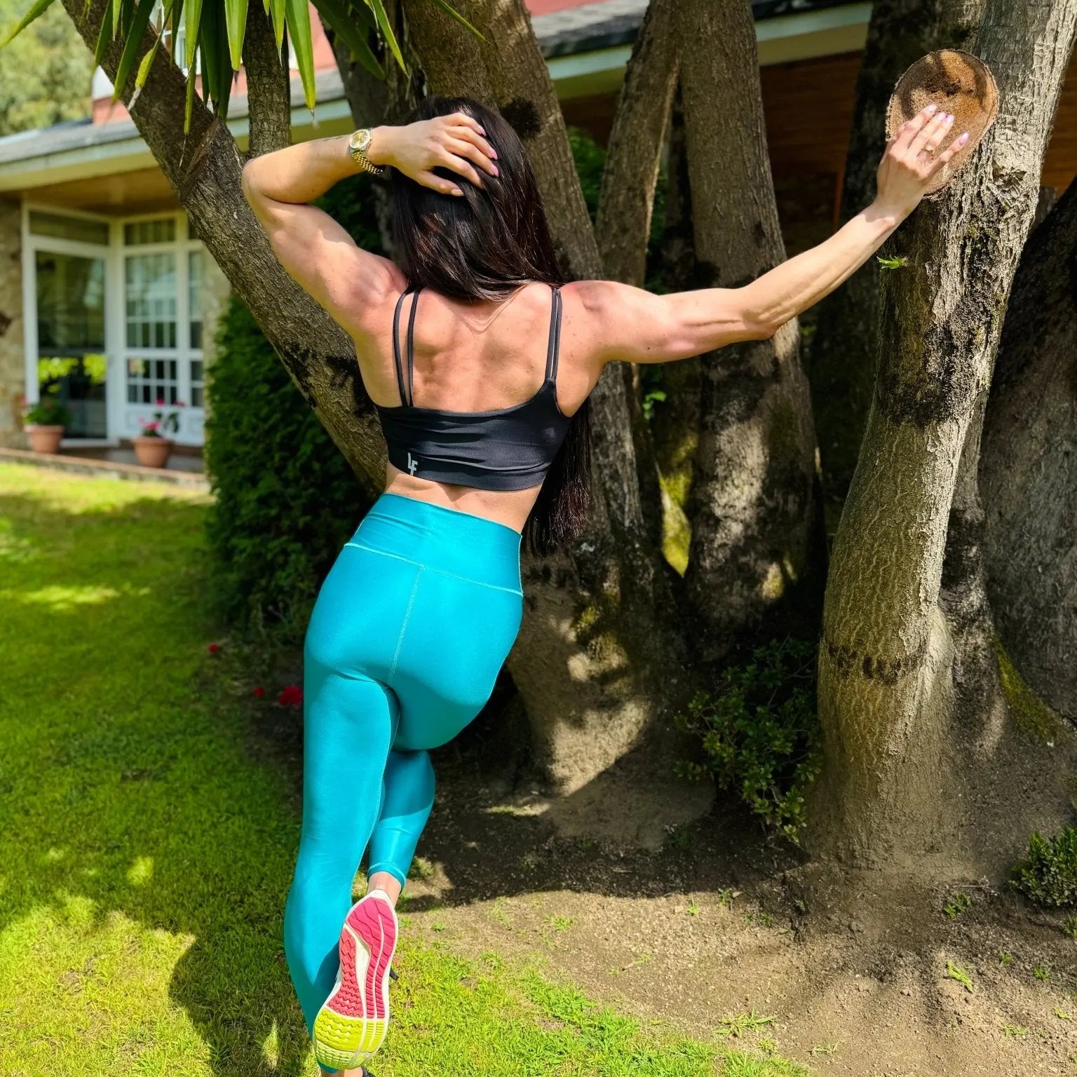 Mujer vistiendo el top deportivo Top Valentina de LUXFEEL en color Negro, con un romántico escote en forma de corazón.