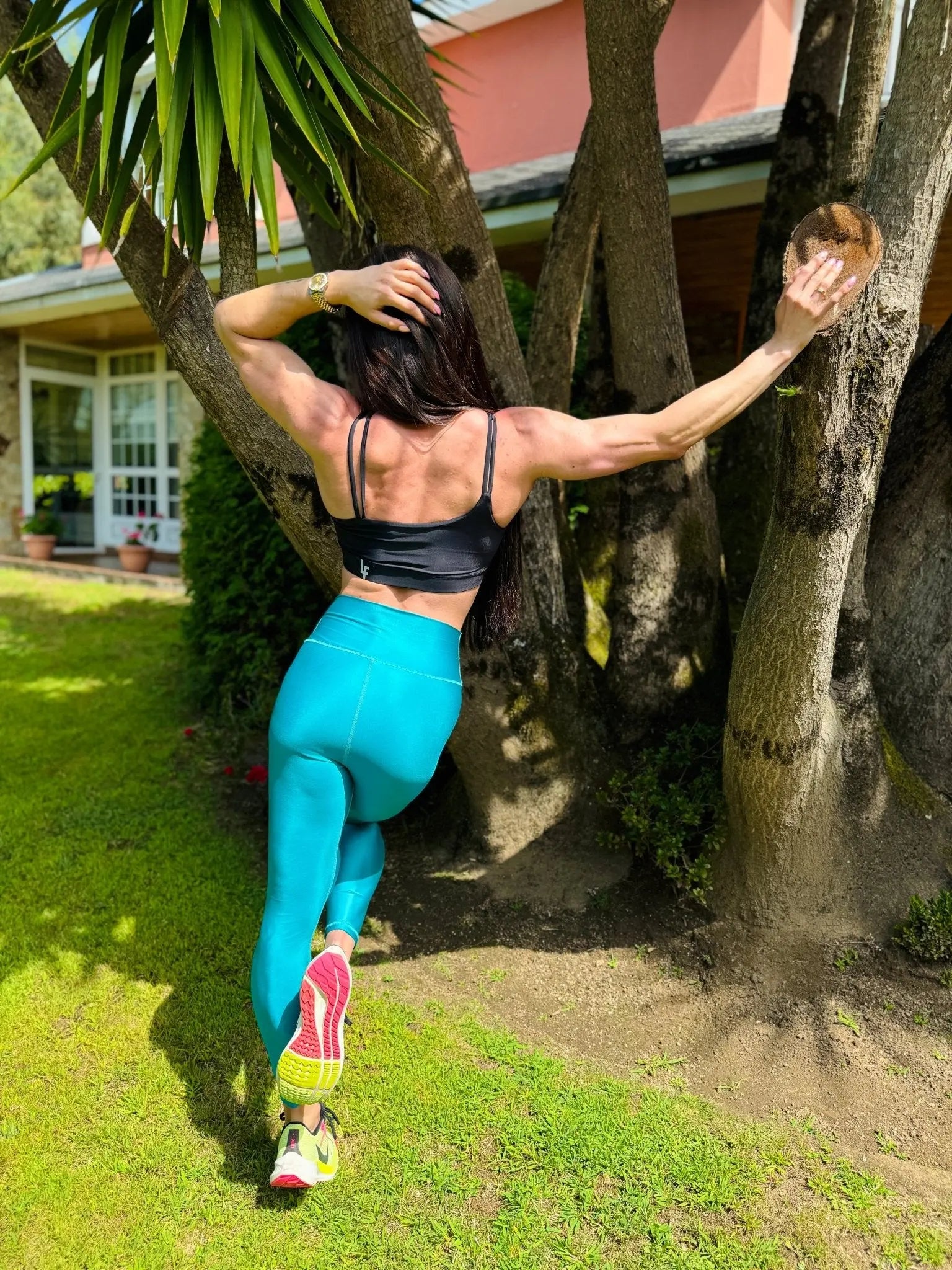 Mujer vistiendo el top deportivo Top Valentina de LUXFEEL en color Negro, con un romántico escote en forma de corazón.