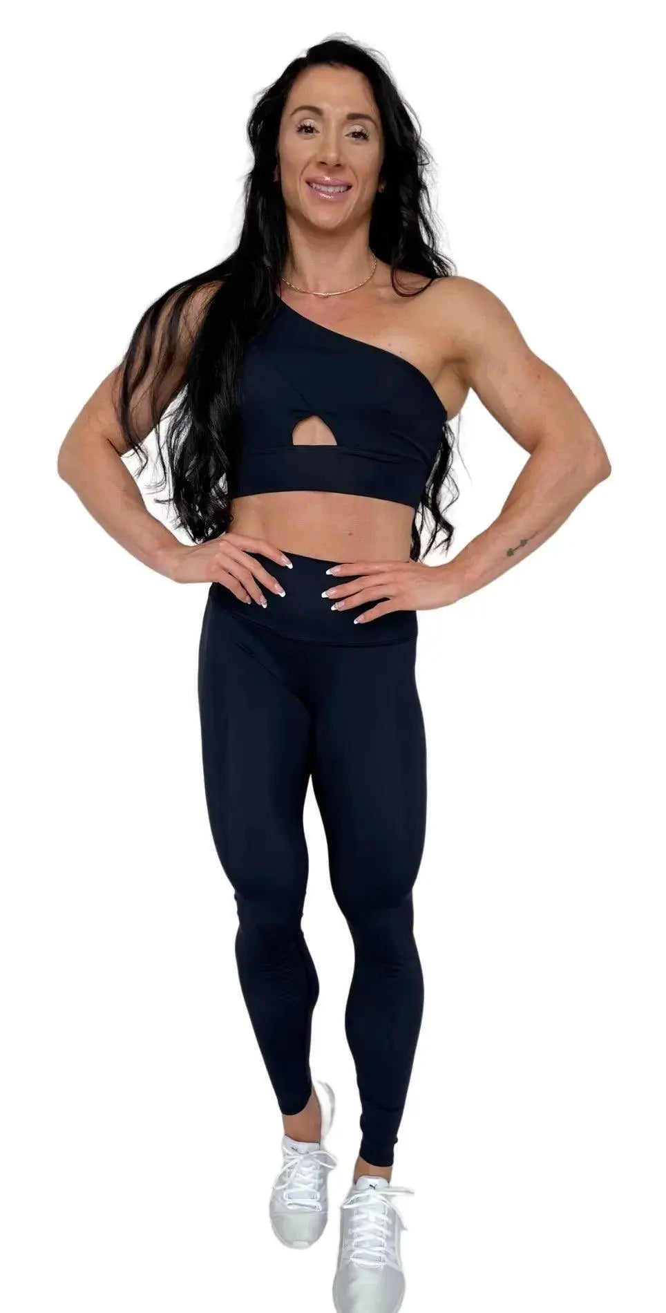 Mujer vistiendo el conjunto deportivo negro de LUXFEEL, compuesto por el top asimétrico Carmela y el legging escultor Myself.