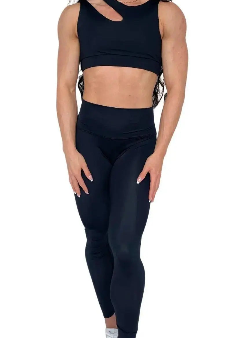 Mujer luciendo el top asimétrico Top Vanesa de LUXFEEL en color Negro, con un diseño de apertura en el hombro y soporte extra.