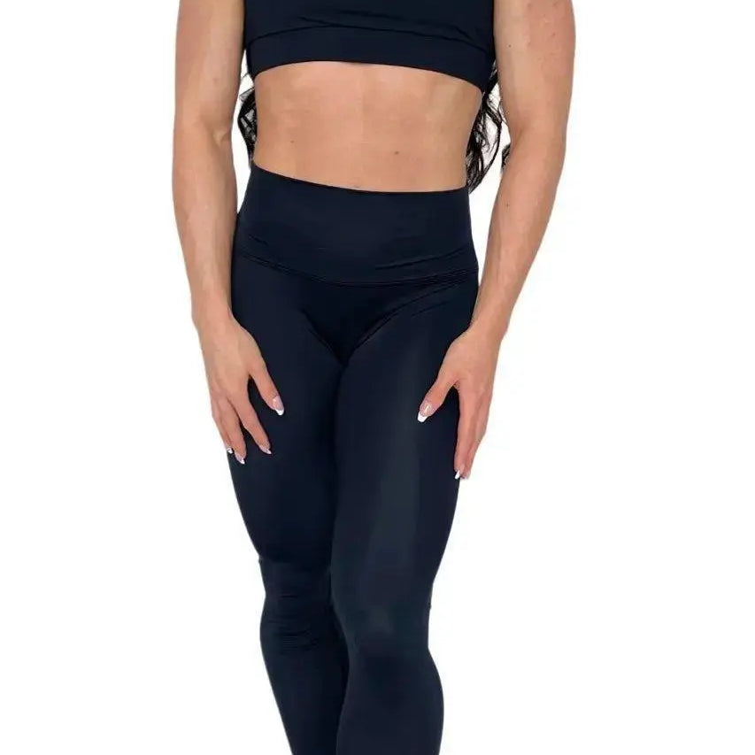 Mujer luciendo el top asimétrico Top Vanesa de LUXFEEL en color Negro, con un diseño de apertura en el hombro y soporte extra.