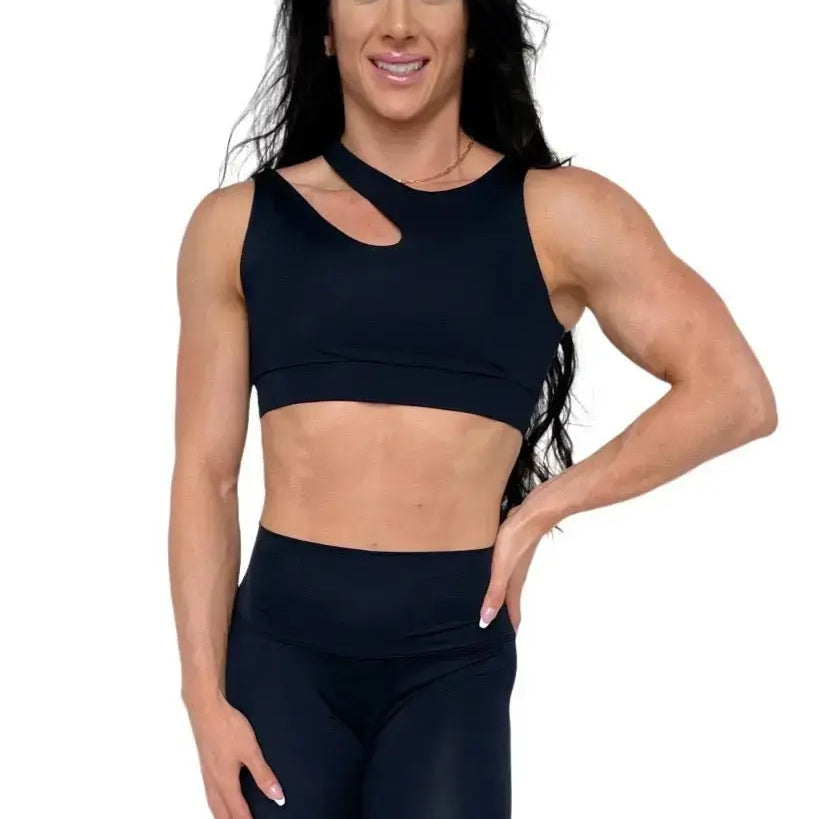 Mujer luciendo el top asimétrico Top Vanesa de LUXFEEL en color Negro, con un diseño de apertura en el hombro y soporte extra.