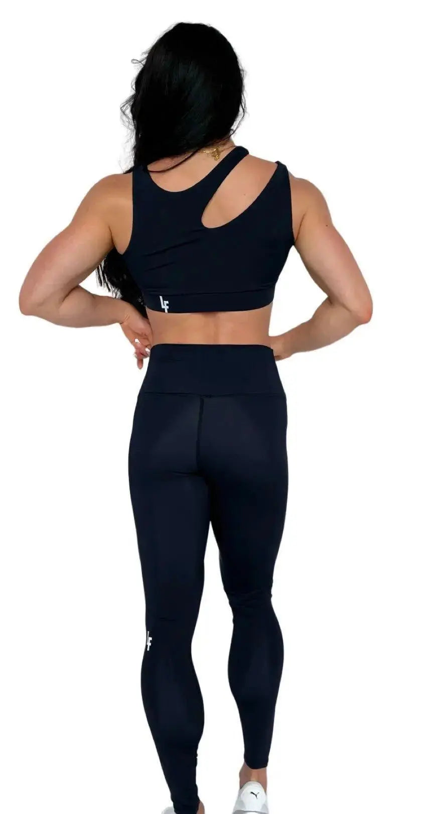 Mujer luciendo el top asimétrico Top Vanesa de LUXFEEL en color Negro, con un diseño de apertura en el hombro y soporte extra.