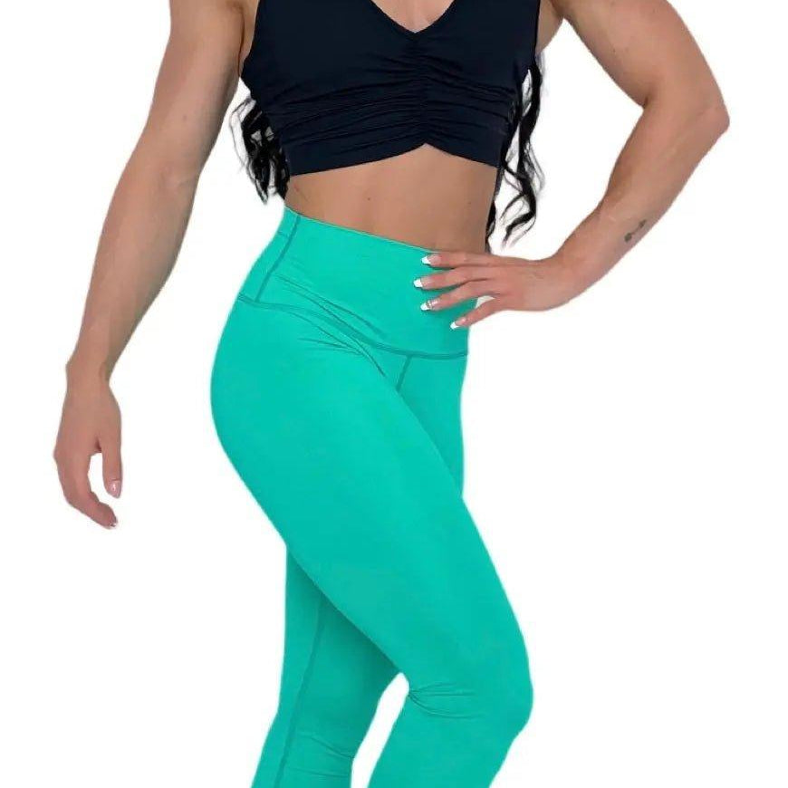 Mujer vistiendo el crop top deportivo Top Adela de LUXFEEL en color Negro, con escote en V y detalle fruncido en el pecho.