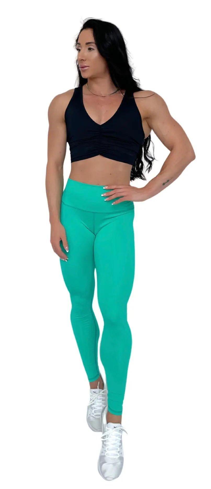 Mujer vistiendo el crop top deportivo Top Adela de LUXFEEL en color Negro, con escote en V y detalle fruncido en el pecho.