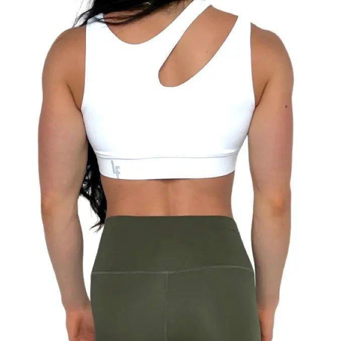 Mujer luciendo el top asimétrico Top Vanesa de LUXFEEL en color Blanco, con un diseño de apertura en el hombro y soporte extra.