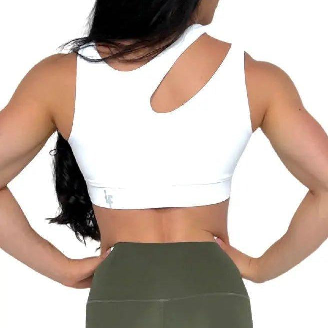 Mujer luciendo el top asimétrico Top Vanesa de LUXFEEL en color Blanco, con un diseño de apertura en el hombro y soporte extra.