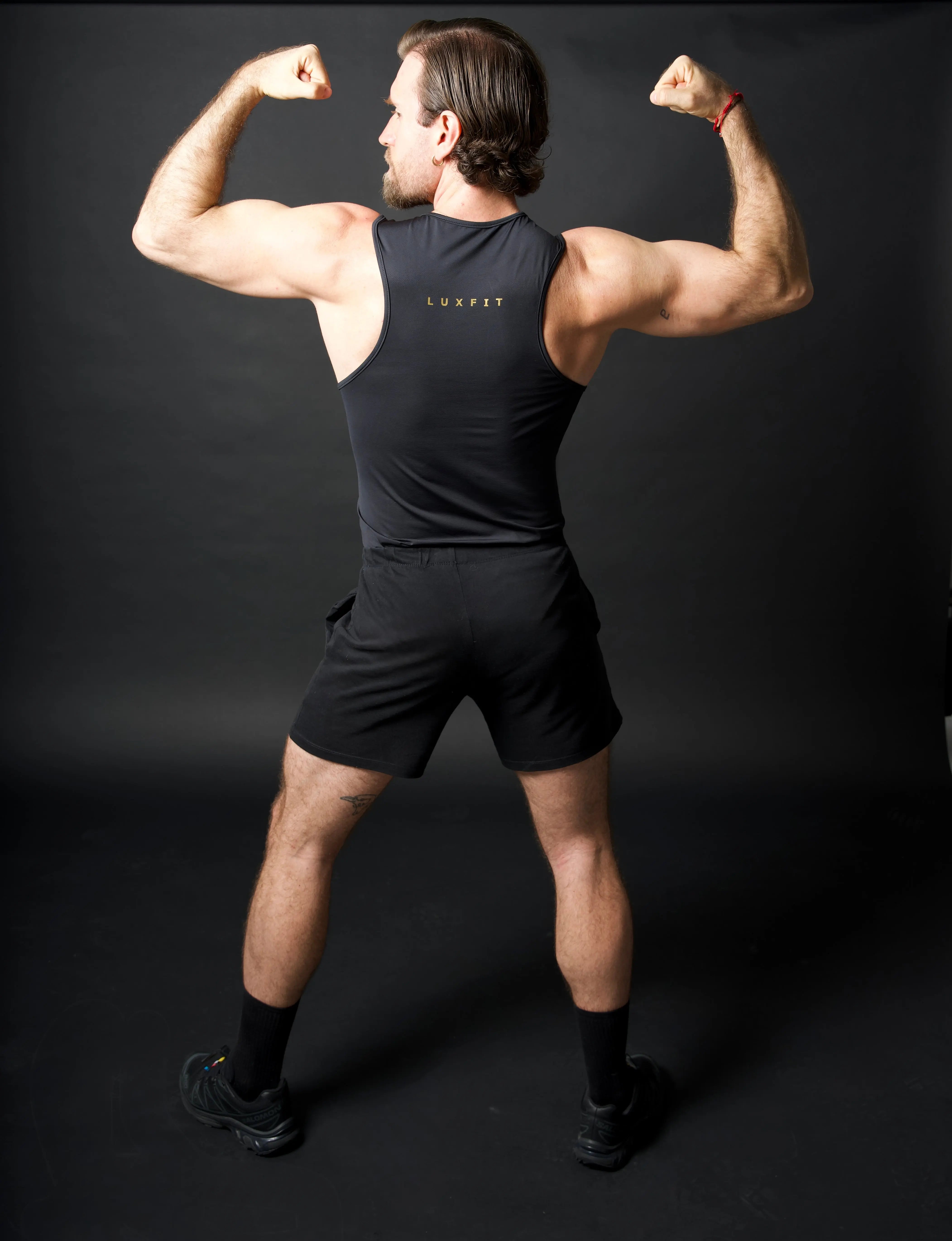 Hombre de espaldas vistiendo la camiseta técnica sin mangas MAN-U de LUXFEEL en color Negro