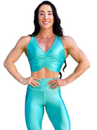 Mujer vistiendo el conjunto deportivo azul celeste de LUXFEEL, compuesto por el crop top brillante Adela Pearl Shine y el legging escultor Myself.