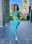 Mujer vistiendo el conjunto deportivo azul celeste de LUXFEEL, compuesto por el crop top brillante Adela Pearl Shine y el legging escultor Myself.