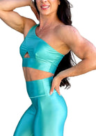 Mujer vistiendo el conjunto azul celeste brillante de LUXFEEL, compuesto por el top asimétrico Carmela (un solo hombro y apertura en el escote) y el legging Pearl Shine a juego.
