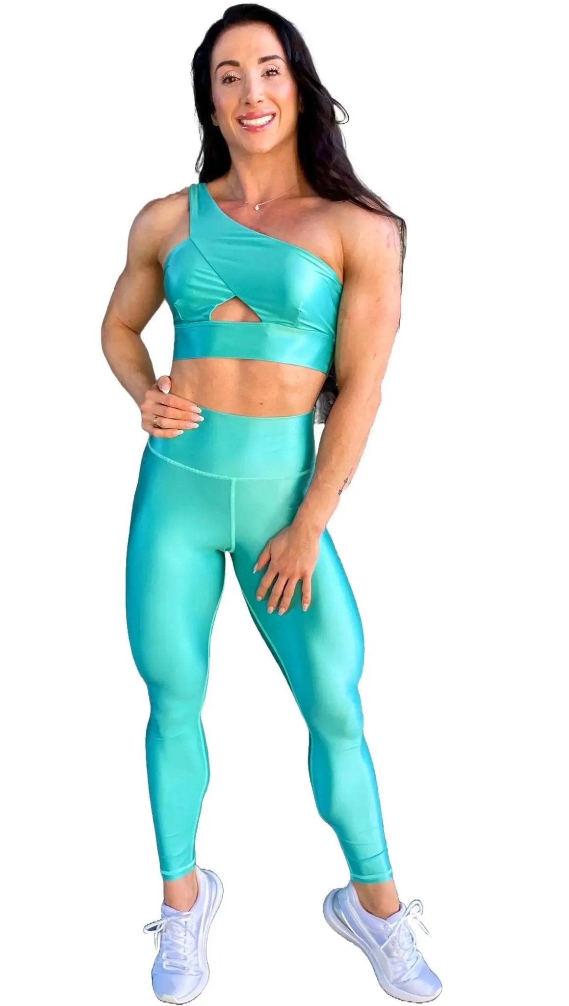 Mujer vistiendo el conjunto azul celeste brillante de LUXFEEL, compuesto por el top asimétrico Carmela (un solo hombro y apertura en el escote) y el legging Pearl Shine a juego.