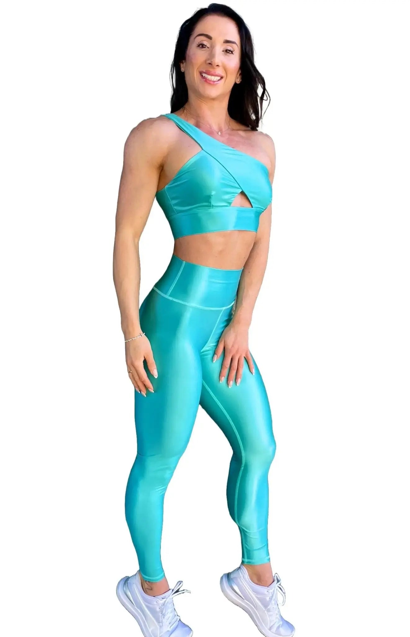 Mujer vistiendo el conjunto azul celeste brillante de LUXFEEL, compuesto por el top asimétrico Carmela (un solo hombro y apertura en el escote) y el legging Pearl Shine a juego.