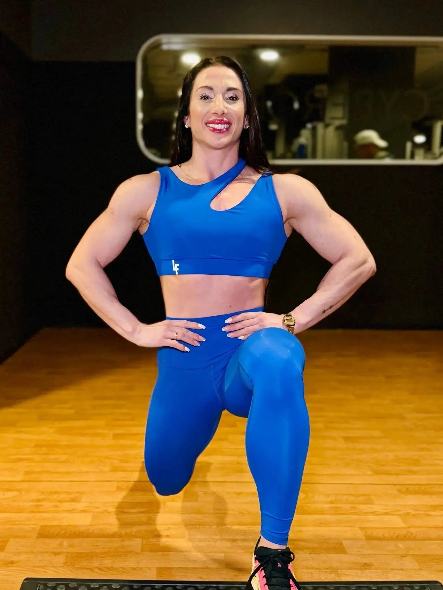 Mujer vistiendo el conjunto deportivo azul de LUXFEEL, compuesto por el top asimétrico Vanesa y el legging escultor Myself.