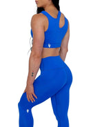 Mujer vistiendo el conjunto deportivo azul de LUXFEEL, compuesto por el top asimétrico Vanesa y el legging escultor Myself.