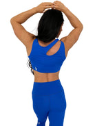Mujer vistiendo el conjunto deportivo azul de LUXFEEL, compuesto por el top asimétrico Vanesa y el legging escultor Myself.