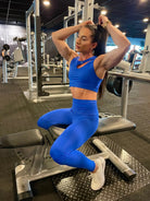 Mujer vistiendo el conjunto deportivo azul de LUXFEEL, compuesto por el top asimétrico Vanesa y el legging escultor Myself.