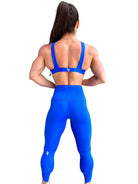 Mujer vistiendo el conjunto deportivo azul de LUXFEEL, con el Top Paula en su estilo de tirantes rectos y el legging escultor Myself.
