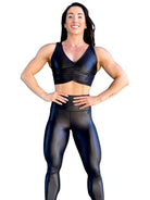 Mujer vistiendo el crop top brillante Top Adela Pearl Shine de LUXFEEL en color Negro Brillante, con escote en V y detalle fruncido en el pecho.