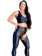 Mujer vistiendo el crop top brillante Top Adela Pearl Shine de LUXFEEL en color Negro Brillante, con escote en V y detalle fruncido en el pecho.