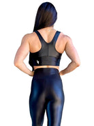 Mujer vistiendo el crop top brillante Top Adela Pearl Shine de LUXFEEL en color Negro Brillante, con escote en V y detalle fruncido en el pecho.