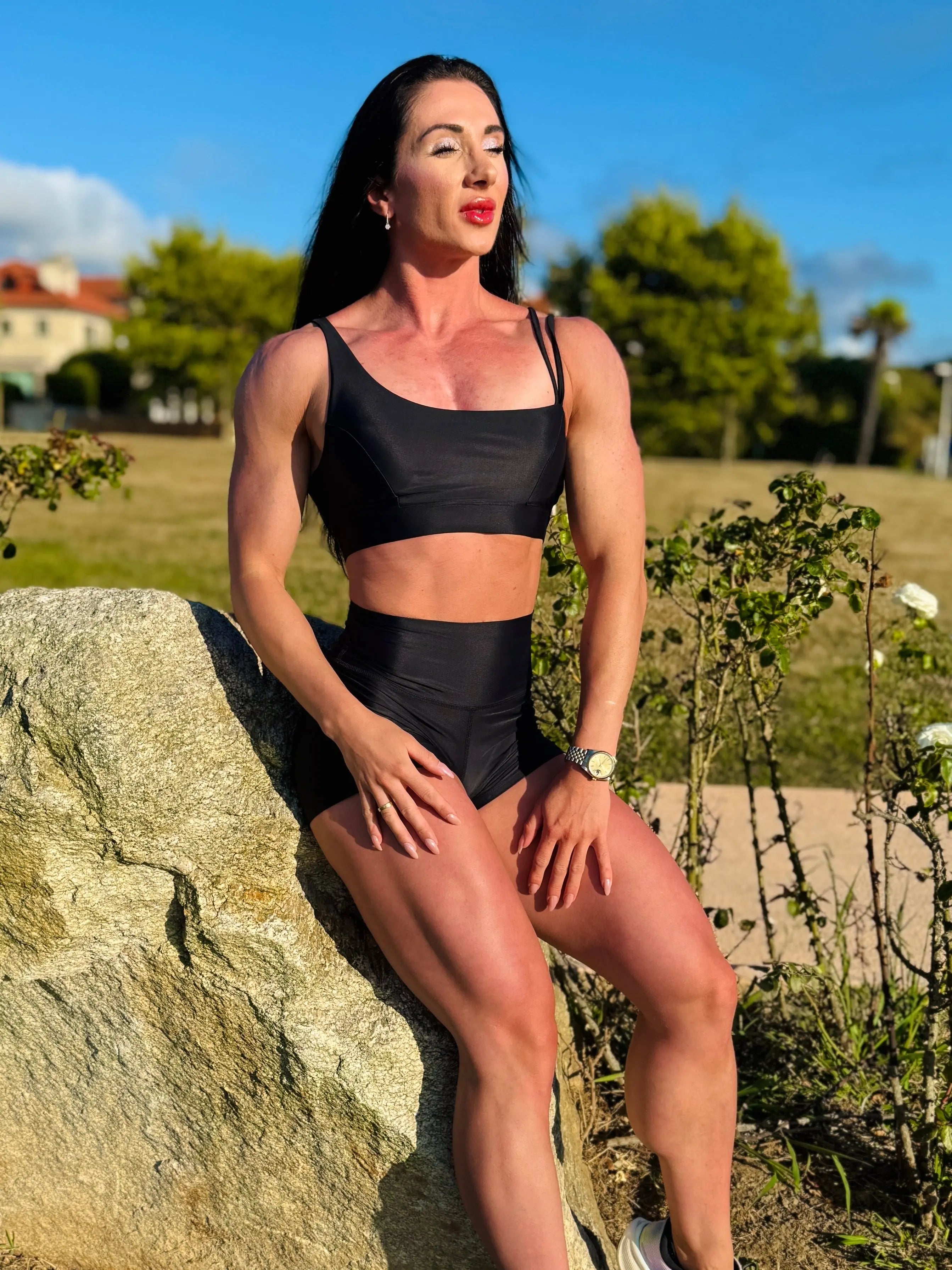 Modelo sentada en una piedra mostrando el conjunto Negro (Top Valentina y Short) - LUXFEEL