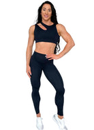 Mujer luciendo el top asimétrico Top Vanesa de LUXFEEL en color Negro, con un diseño de apertura en el hombro y soporte extra.