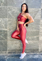 Mujer luciendo el top asimétrico brillante Top Carmela Pearl Shine de LUXFEEL en color Teja Brillante, con diseño de un solo hombro y apertura en el escote.
