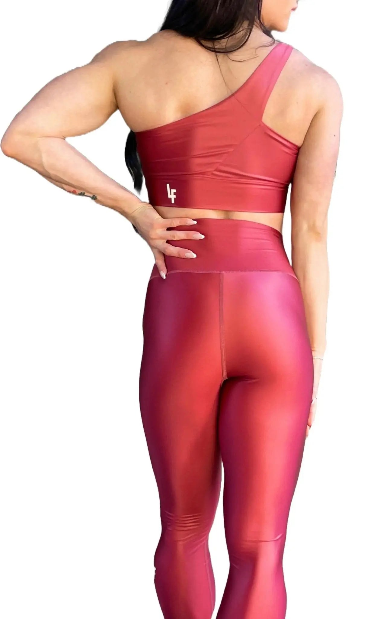 Mujer luciendo el top asimétrico brillante Top Carmela Pearl Shine de LUXFEEL en color Teja Brillante, con diseño de un solo hombro y apertura en el escote.