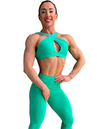Modelo luciendo el conjunto verde de Top Paula y Legging Myself, mostrando el top con su diseño de tirantes cruzados para mayor sujeción.
