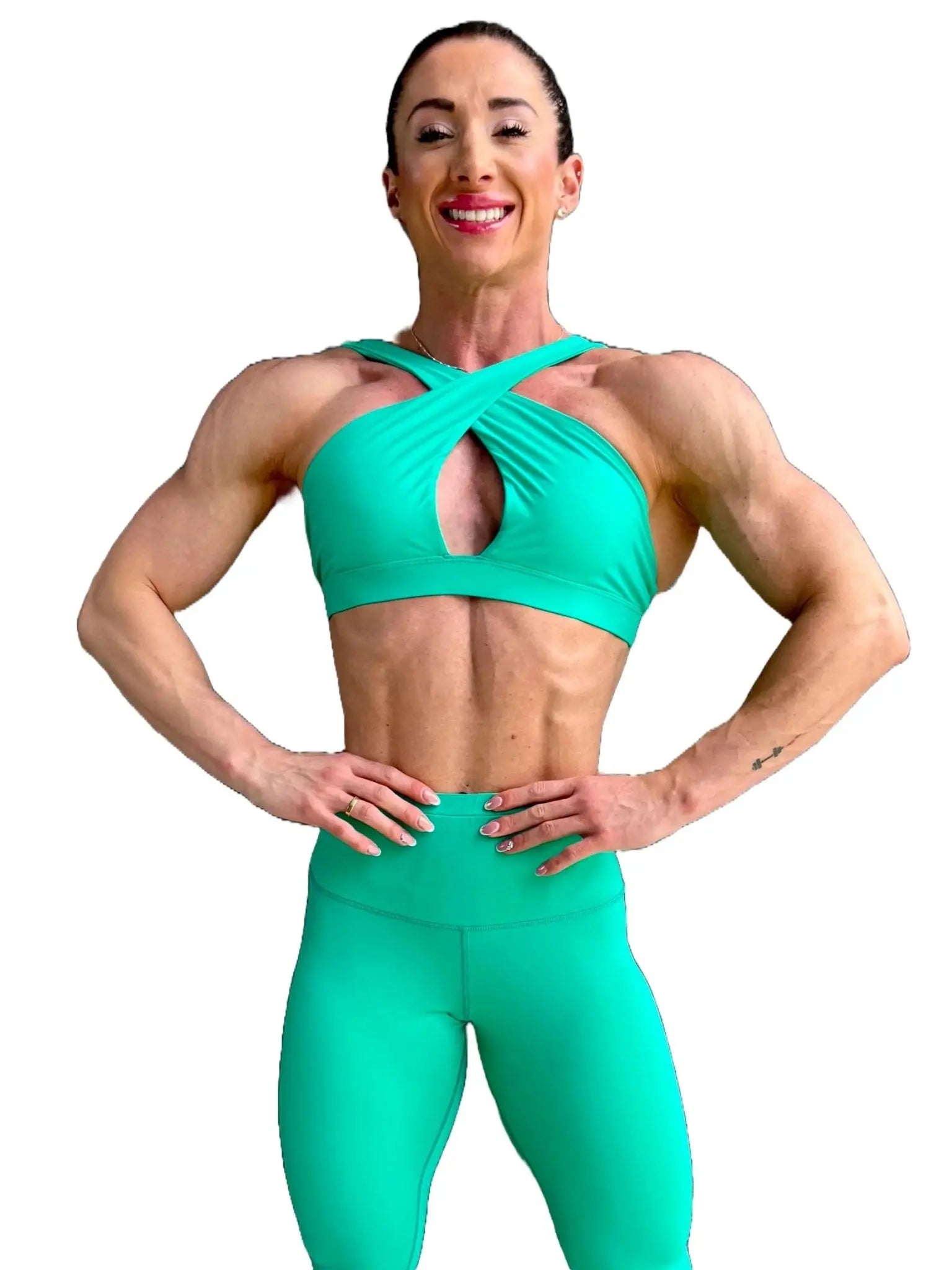 Modelo luciendo el conjunto verde de Top Paula y Legging Myself, mostrando el top con su diseño de tirantes cruzados para mayor sujeción.ción.