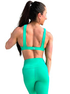 Mujer vistiendo el conjunto deportivo verde de LUXFEEL, con el Top Paula en su estilo de tirantes rectos y el legging escultor Myself.