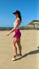 Mujer vistiendo el short deportivo de cintura alta Short Myself de LUXFEEL en color Rosa Bixbita, con diseño moldeador.