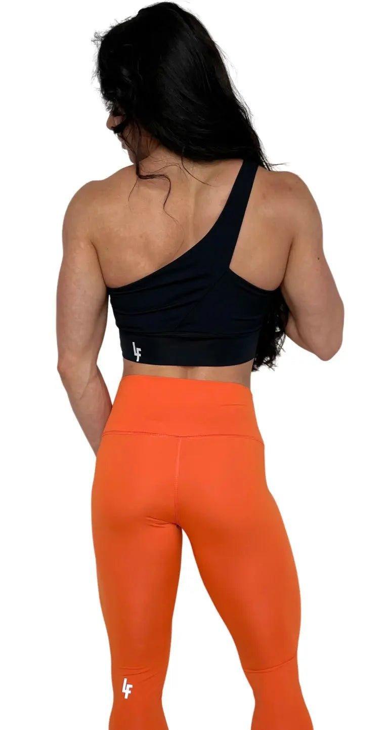 Mujer vistiendo los leggings compresivos de cintura alta Legging Myself de LUXFEEL en color Naranja, que ofrecen un efecto segunda piel.