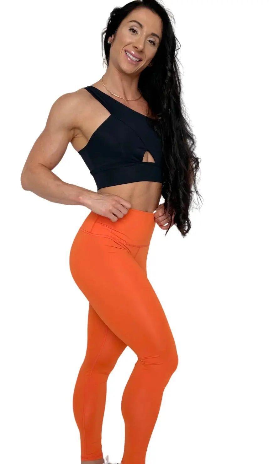 Mujer vistiendo los leggings compresivos de cintura alta Legging Myself de LUXFEEL en color Naranja, que ofrecen un efecto segunda piel.