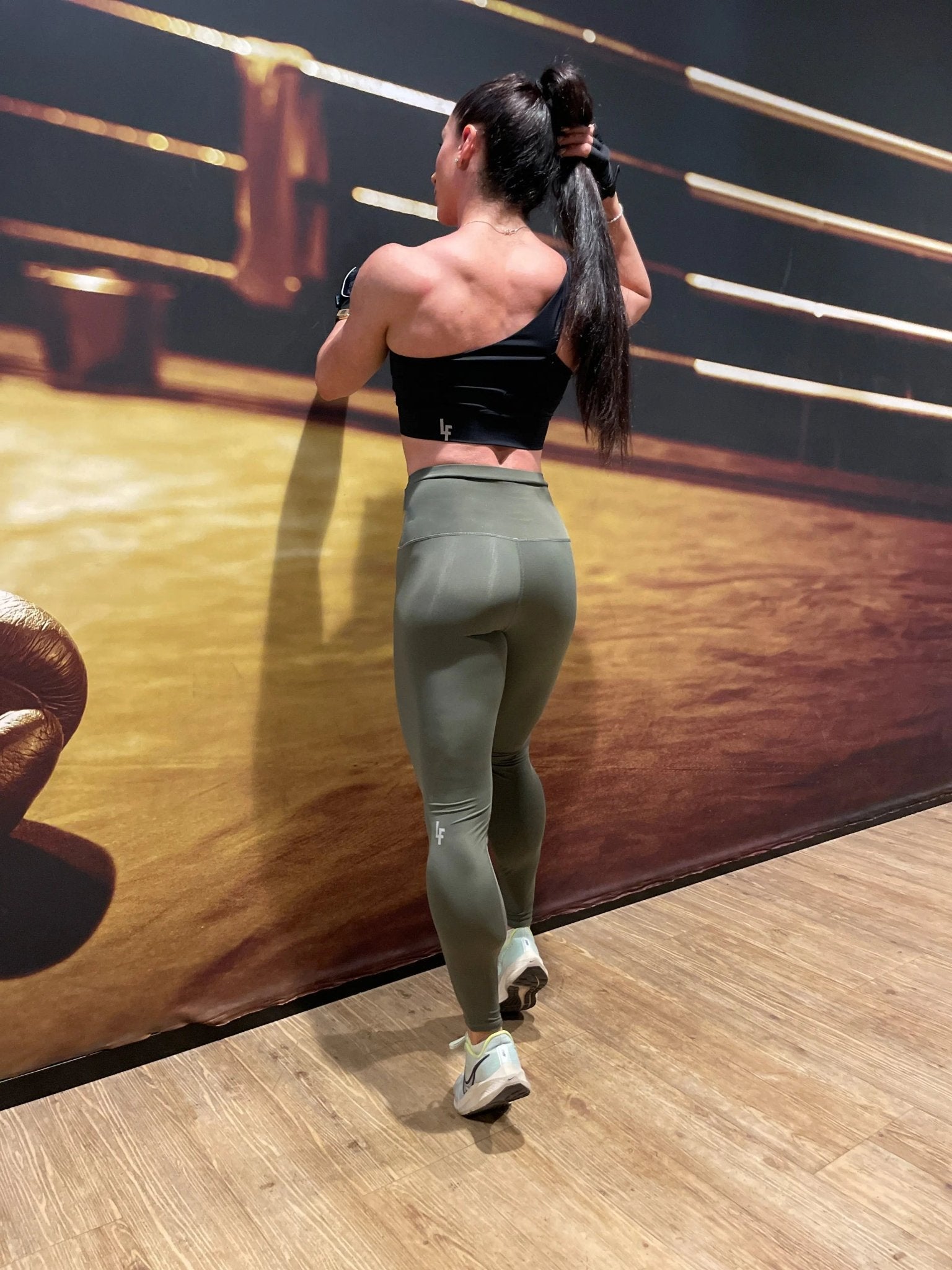 Mujer vistiendo los leggings compresivos de cintura alta Legging Myself de LUXFEEL en color  Verde Caqui / Verde Kaki, que ofrecen un efecto segunda piel.
