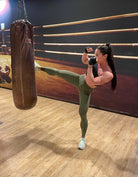 Mujer vistiendo los leggings compresivos de cintura alta Legging Myself de LUXFEEL en color  Verde Caqui / Verde Kaki, que ofrecen un efecto segunda piel.