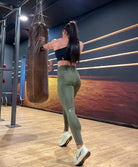 Mujer vistiendo los leggings compresivos de cintura alta Legging Myself de LUXFEEL en color  Verde Caqui / Verde Kaki, que ofrecen un efecto segunda piel.
