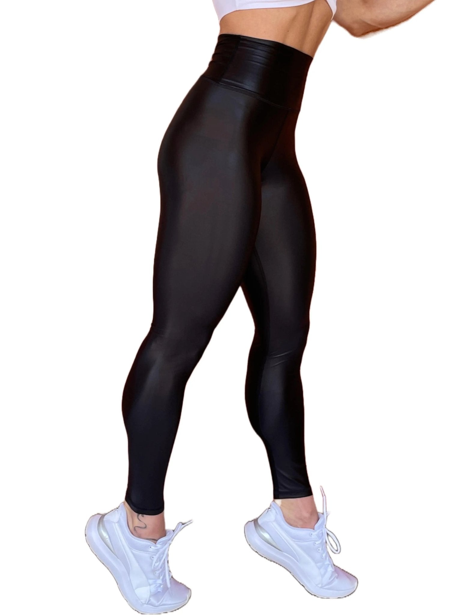 Mujer vistiendo los leggings brillantes de cintura alta Legging Pearl Shine de LUXFEEL en color Negro Brillante, con acabado efecto perla.