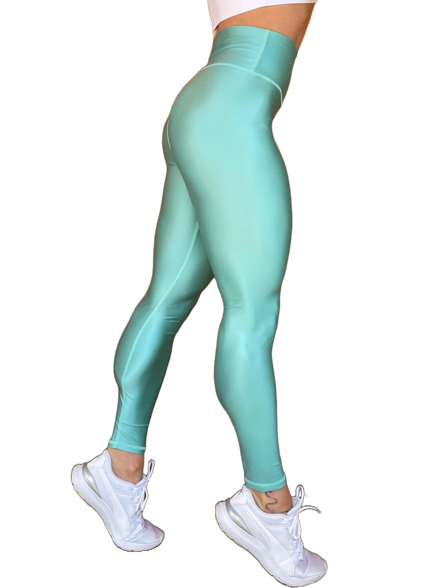 Mujer vistiendo los leggings brillantes de cintura alta Legging Pearl Shine de LUXFEEL en color Azul Celeste Brillante, con acabado efecto perla.