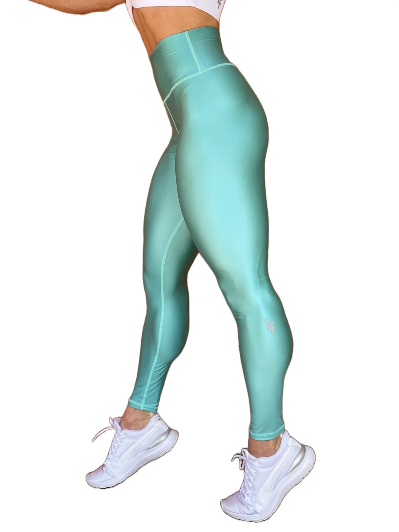 Mujer vistiendo los leggings brillantes de cintura alta Legging Pearl Shine de LUXFEEL en color Azul Celeste Brillante, con acabado efecto perla.