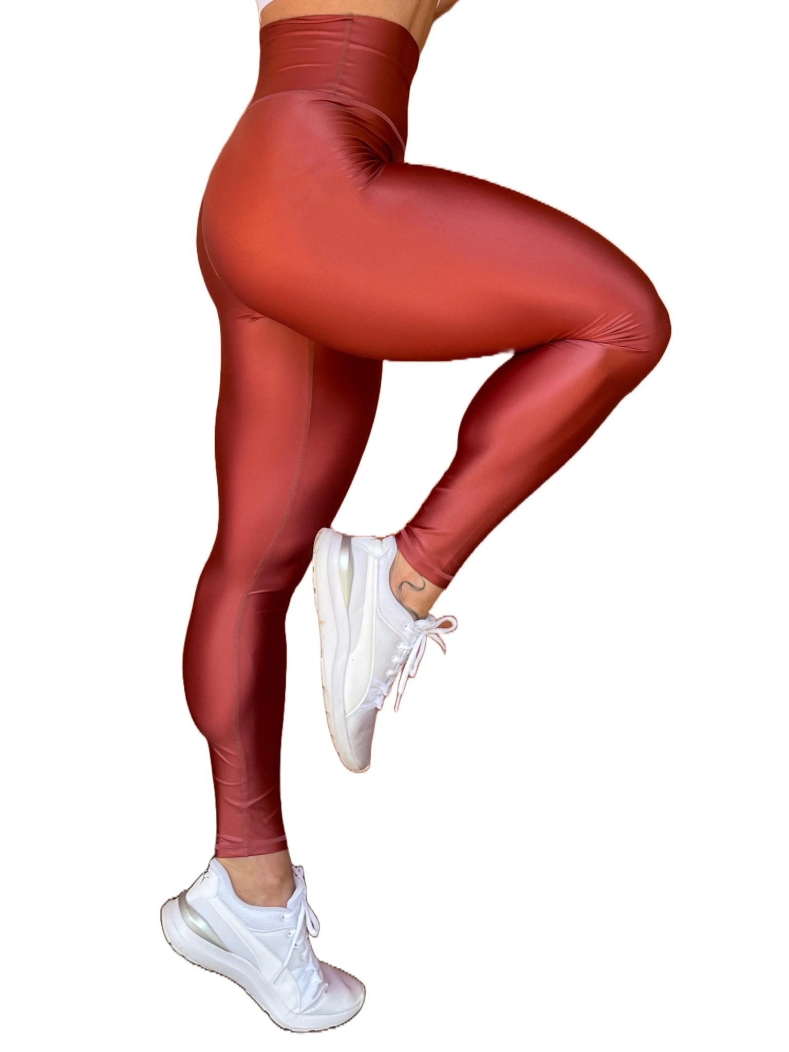 Mujer vistiendo los leggings brillantes de cintura alta Legging Pearl Shine de LUXFEEL en color Teja Brillante / Marron Brillante, con acabado efecto perla.