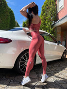 Mujer vistiendo los leggings brillantes de cintura alta Legging Pearl Shine de LUXFEEL en color Teja Brillante / Marron Brillante, con acabado efecto perla.