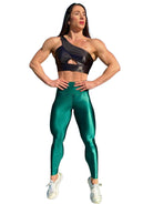 Mujer vistiendo los leggings brillantes de cintura alta Legging Pearl Shine de LUXFEEL en color Verde Botella Brillante, con acabado efecto perla.