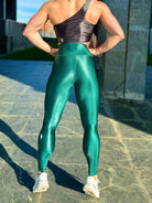 Mujer vistiendo los leggings brillantes de cintura alta Legging Pearl Shine de LUXFEEL en color Verde Botella Brillante, con acabado efecto perla.